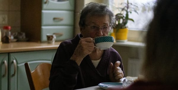 old woman drinking tea at the dinner table